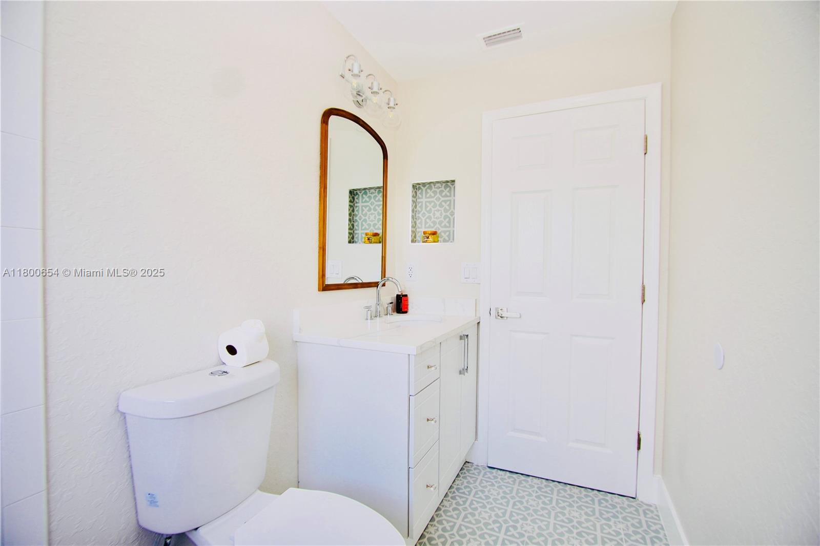 244 Northwest 6th Avenue, Unit 244 Delray Beach, FL 33444 - Photo 29 of 35 a bathroom with a sink a toilet and a mirror