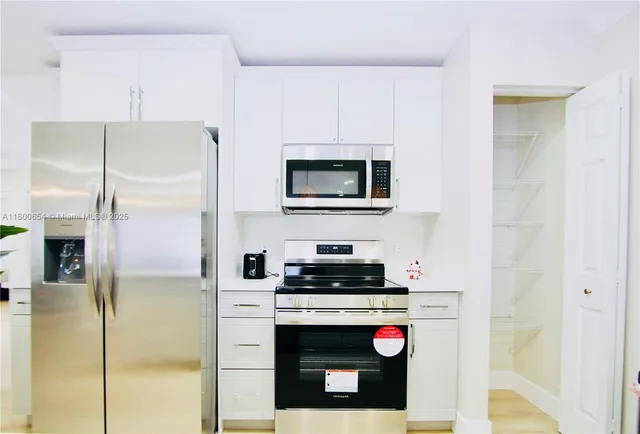 a kitchen with stainless steel appliances granite countertop a refrigerator and a stove top oven