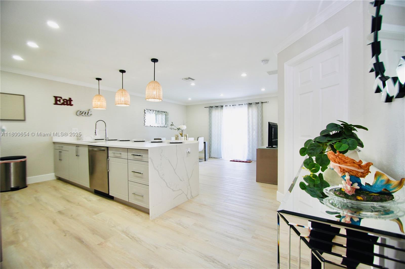244 Northwest 6th Avenue, Unit 244 Delray Beach, FL 33444 - Photo 6 of 35 a large white kitchen with stainless steel appliances granite countertop a sink dishwasher a stove and white cabinets with wooden floor