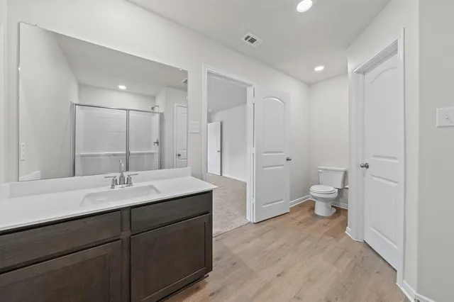 a spacious bathroom with a double vanity sink toilet and shower