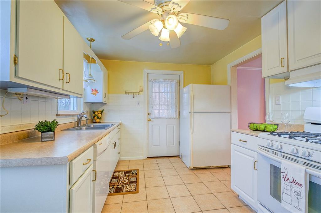 33 Kennedy Lane McKees Rocks, PA 15136 - Photo 7 of 19 a kitchen with a sink a refrigerator a stove a washer and dryer