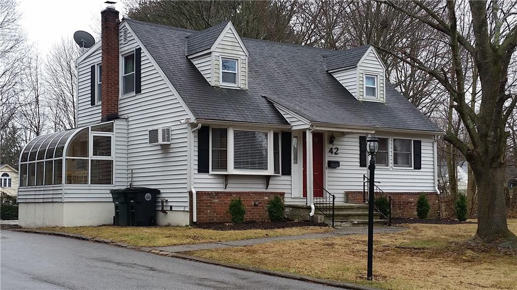 a view of a house with a yard and large tree