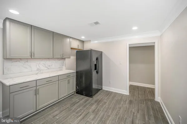 a kitchen with a sink a refrigerator and wooden floor