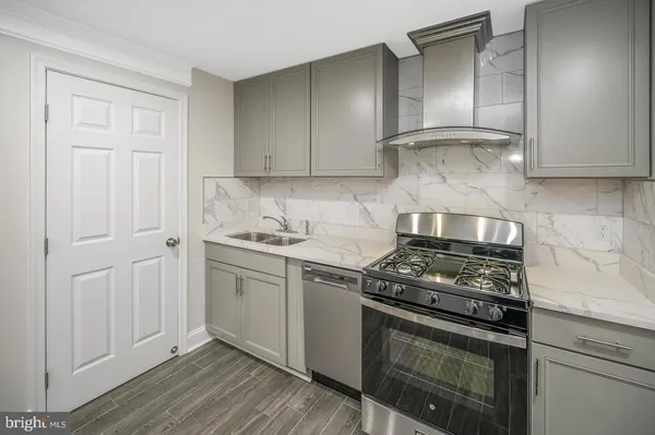 a kitchen with granite countertop white cabinets and stainless steel appliances