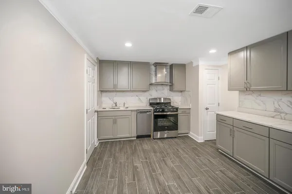 a kitchen with a sink wooden floor and stainless steel appliances