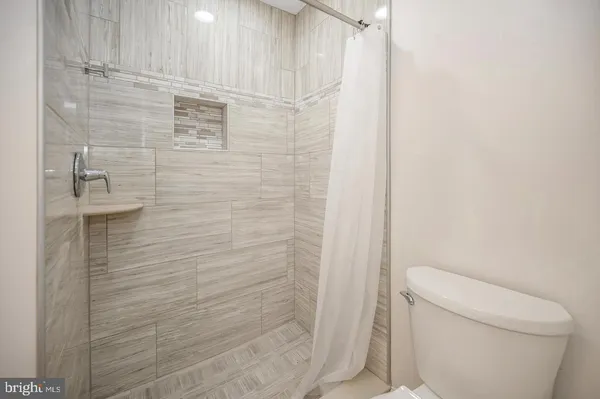 a bathroom with a toilet and a shower