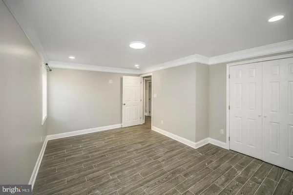 a view of an empty room with wooden floor