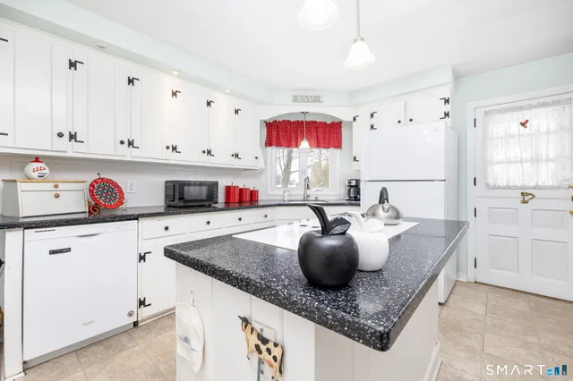 a kitchen with cabinets a sink dishwasher and a stove with wooden floor