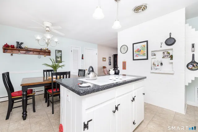 a dining table with kitchen island white cabinets and stainless steel appliances