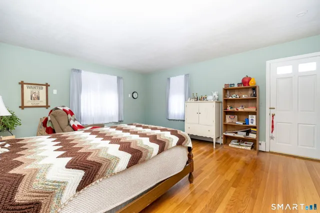 a bedroom with a bed and a wooden floor