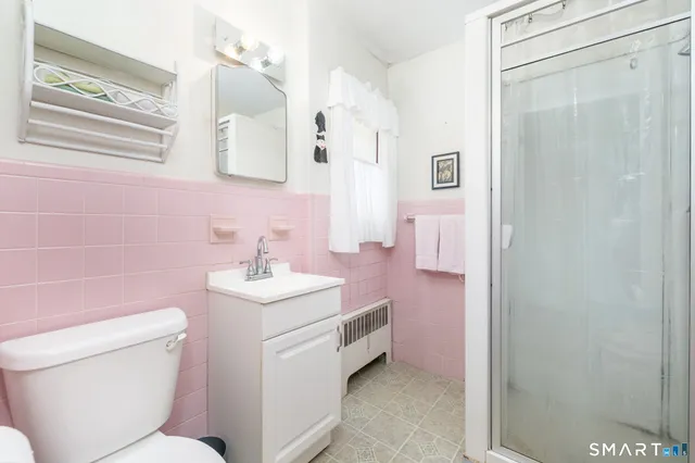 a bathroom with a sink toilet vanity and shower