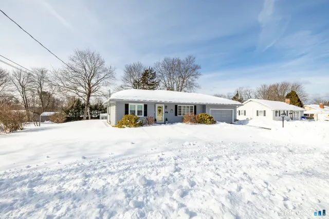 a front view of a house with a yard covered in snow