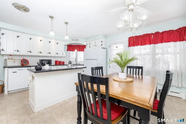 a kitchen with kitchen island granite countertop a table chairs stove and cabinets