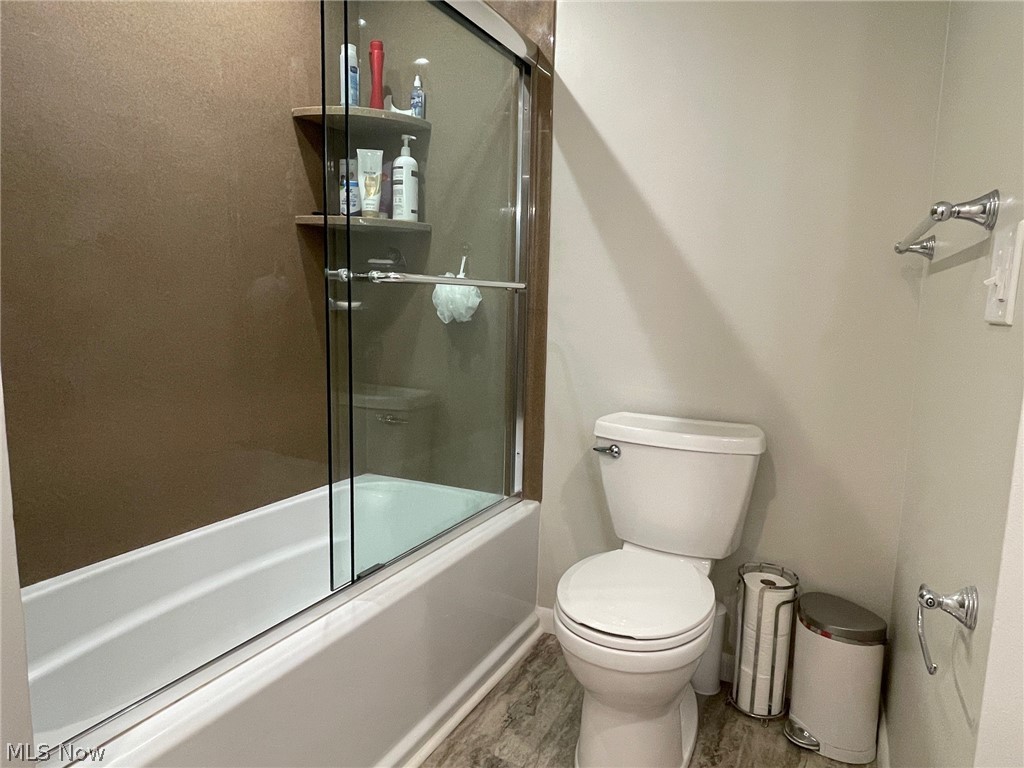 6468 State Road, Unit L10 Cleveland, OH 44134 - Photo 11 of 15 Bathroom with wood-type flooring, toilet, and bath / shower combo with glass door