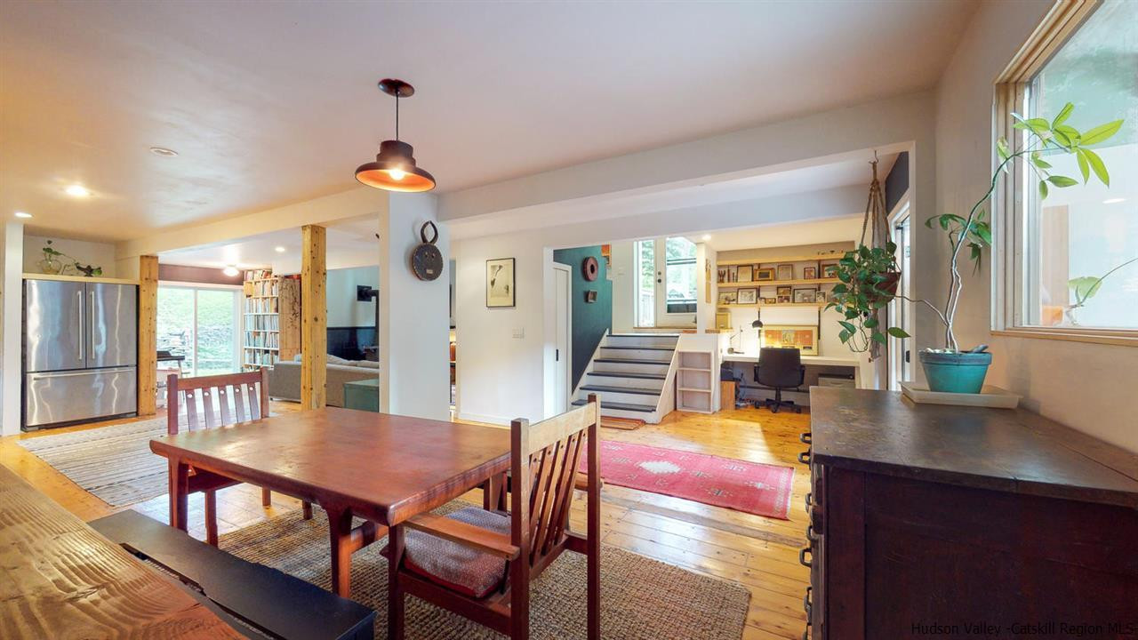 209-211 Fish Creek Road Saugerties, NY 12477 - Photo 16 of 35 a view of a dining room and livingroom with furniture wooden floor a rug a fireplace and a chandelier
