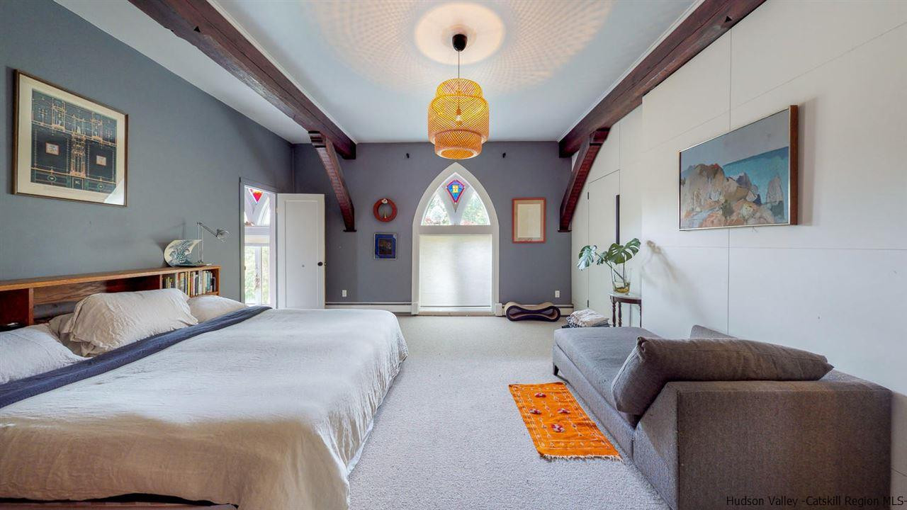 209-211 Fish Creek Road Saugerties, NY 12477 - Photo 20 of 35 a spacious bedroom with a bed and a chandelier