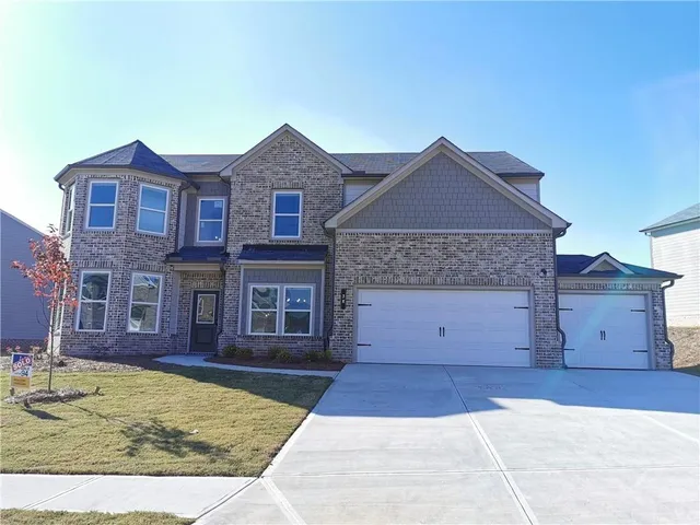 a front view of a house with a yard and garage