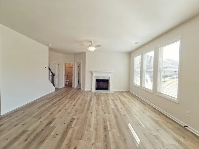 a view of empty room with wooden floor and fireplace