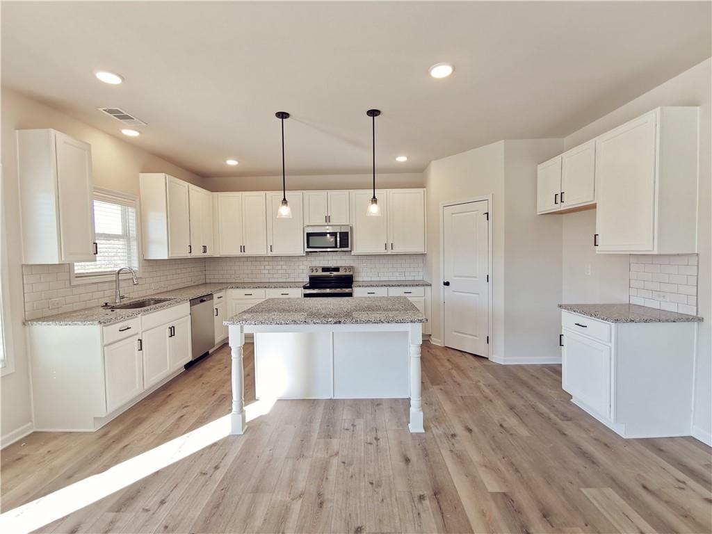 38 Longhorn Way Auburn, GA 30011 - Photo 12 of 36 a large kitchen with cabinets wooden floor and stainless steel appliances