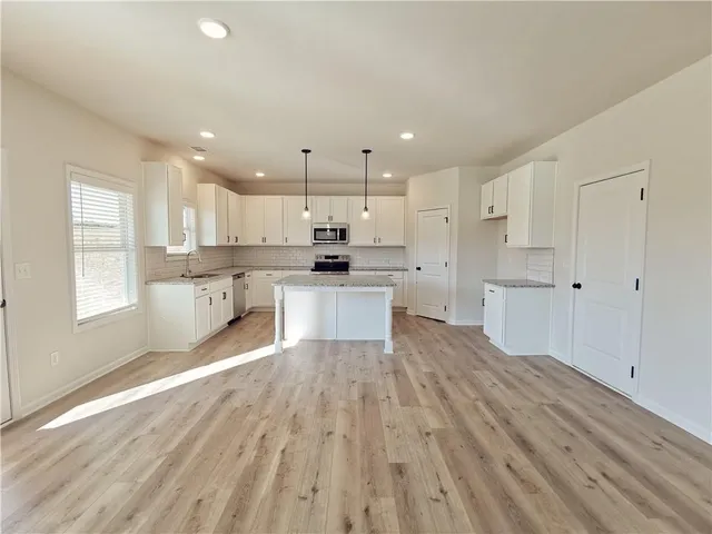 a large kitchen with cabinets and wooden floor