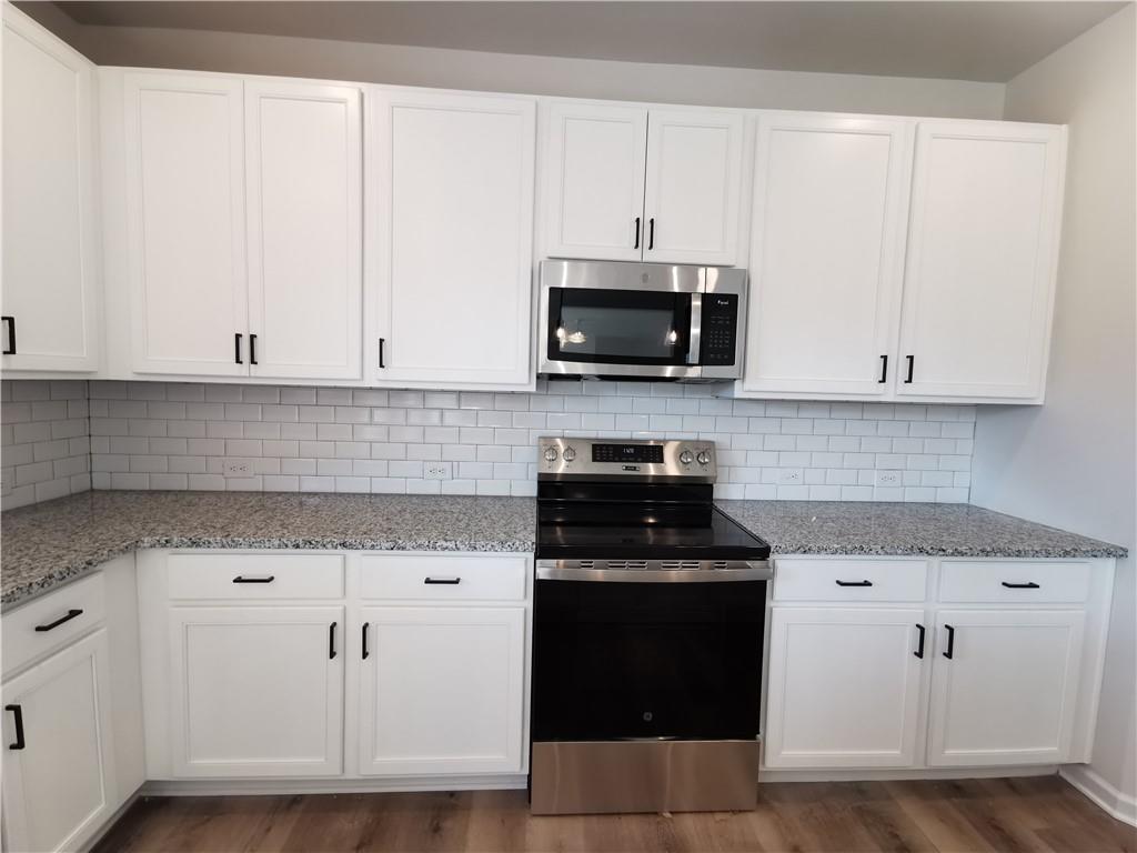 38 Longhorn Way Auburn, GA 30011 - Photo 15 of 36 a kitchen with white cabinets and black appliances
