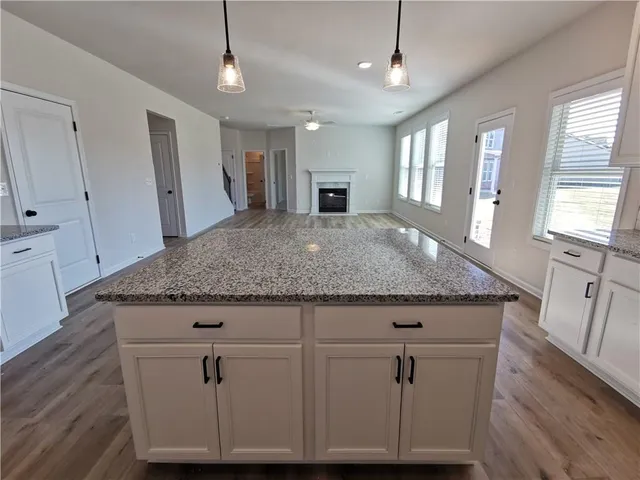 a view of kitchen island with granite countertop cabinets and wooden floor