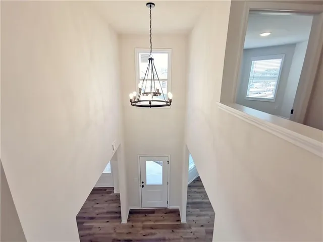 a view of a hallway with wooden floor and staircase