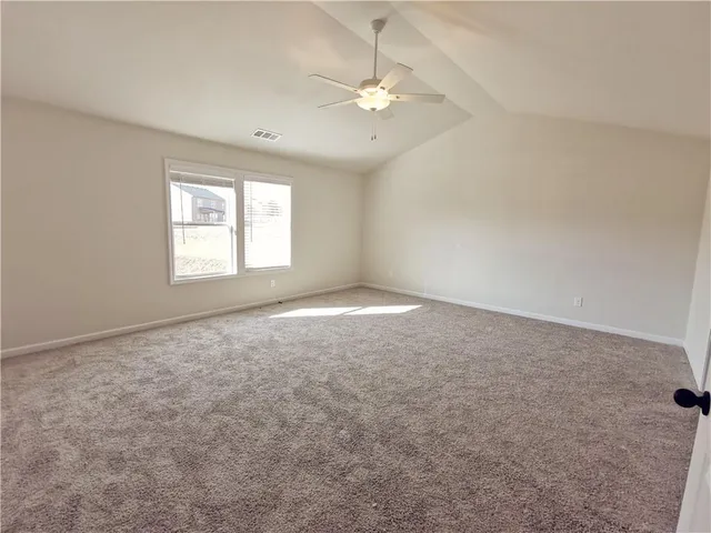 an empty room with windows and fan