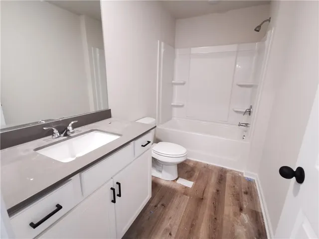 a bathroom with a granite countertop sink toilet a shower and a mirror