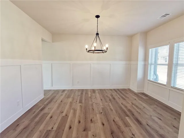 a view of a room with wooden floor closet and windows