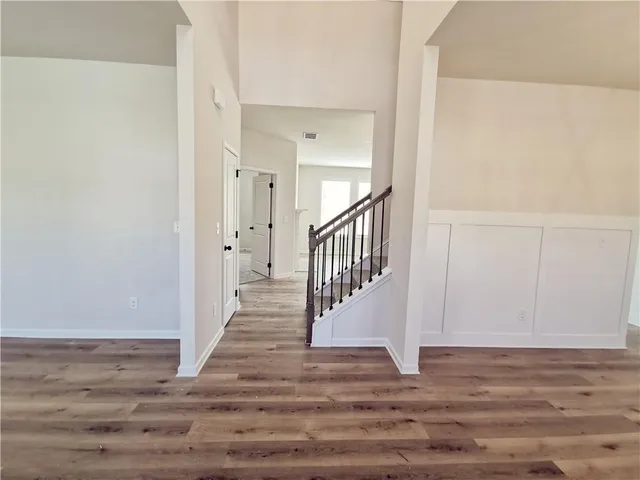 a view of a hallway with wooden floor and entryway