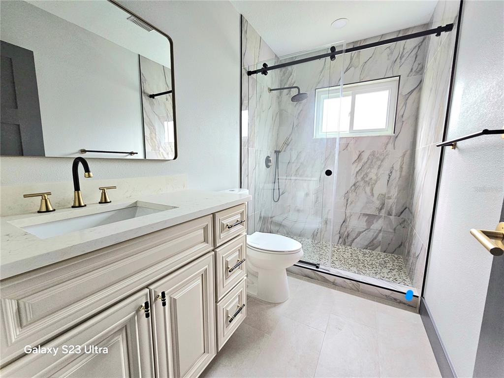 2435 Sumatran Way, Unit 35 Clearwater, FL 33763 - Photo 14 of 69 a bathroom with a granite countertop sink a toilet a mirror and shower