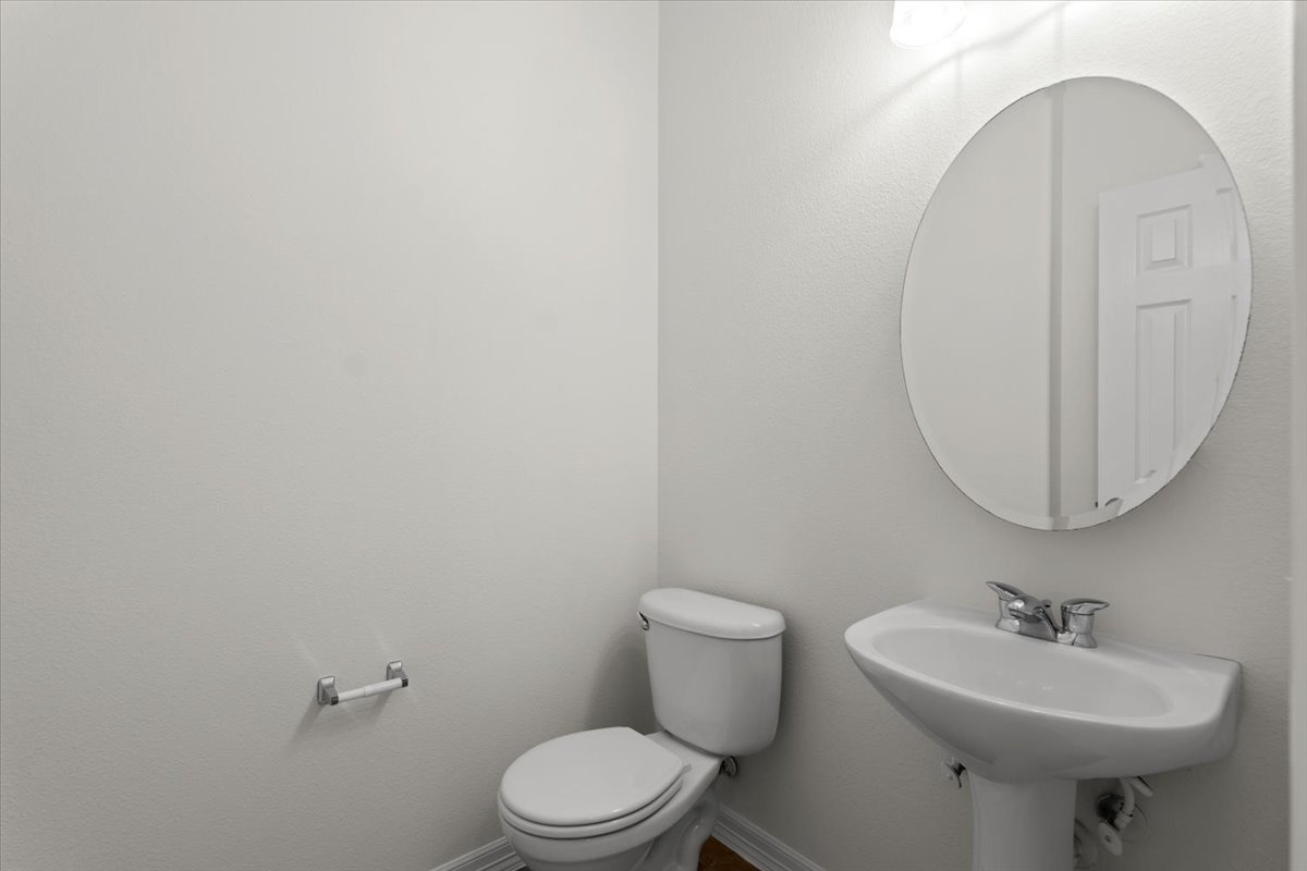 2304 Village View Loop Pflugerville, TX 78660 - Photo 21 of 40 A well-appointed powder room features a pedestal sink and modern toilet.
