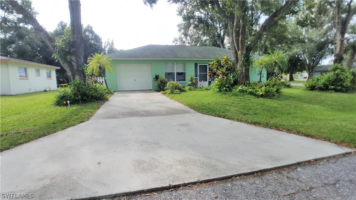 2332 Caladium Road Fort Myers, FL 33905 - Photo 1 of 17 a front view of a house with a yard and trees