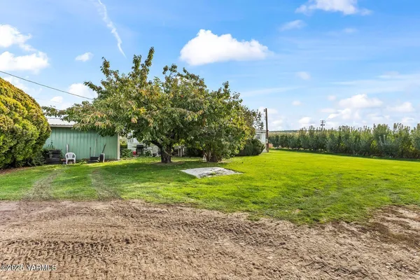 a view of a green field with wooden fence