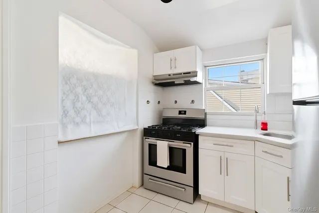 a kitchen with white cabinets and white appliances