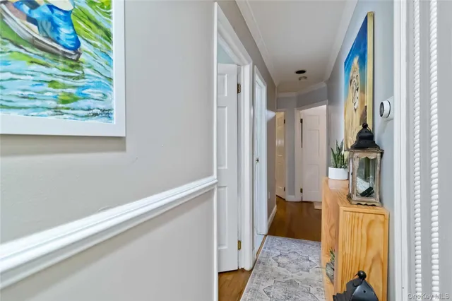 a view of hallway with wooden floor and a bedroom