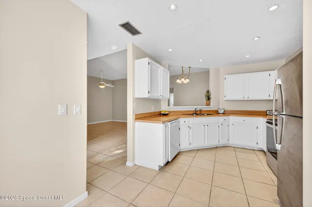 a large white kitchen with a sink and refrigerator