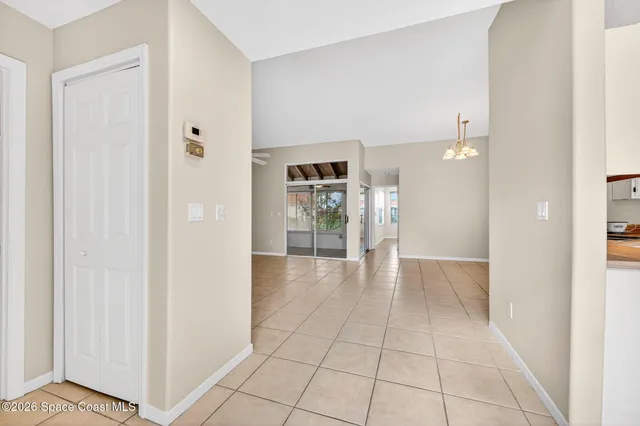 a view of a hallway with wooden floor and a living room