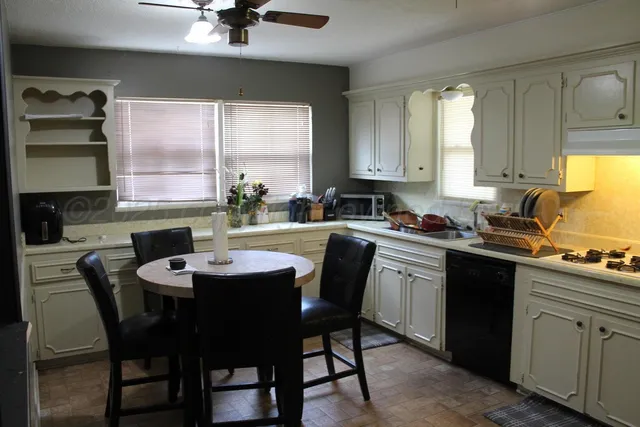 a kitchen with a table chairs sink and cabinets