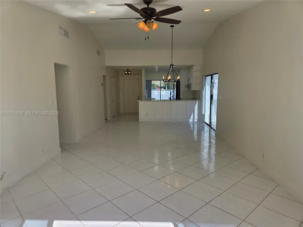 wooden floor in an empty room with a chandelier