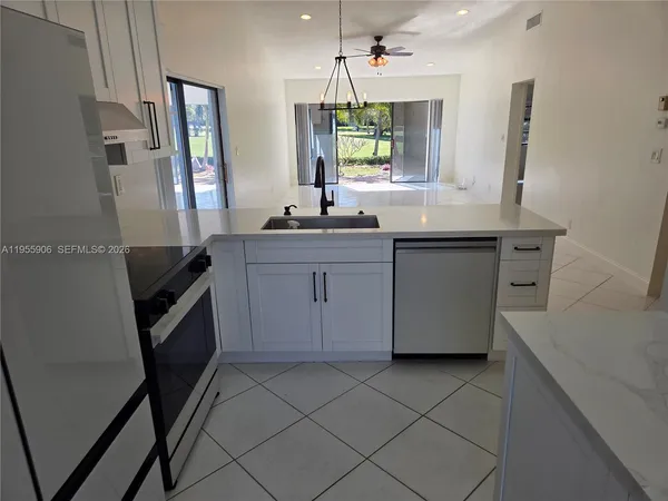 a kitchen with granite countertop a sink stove and cabinets