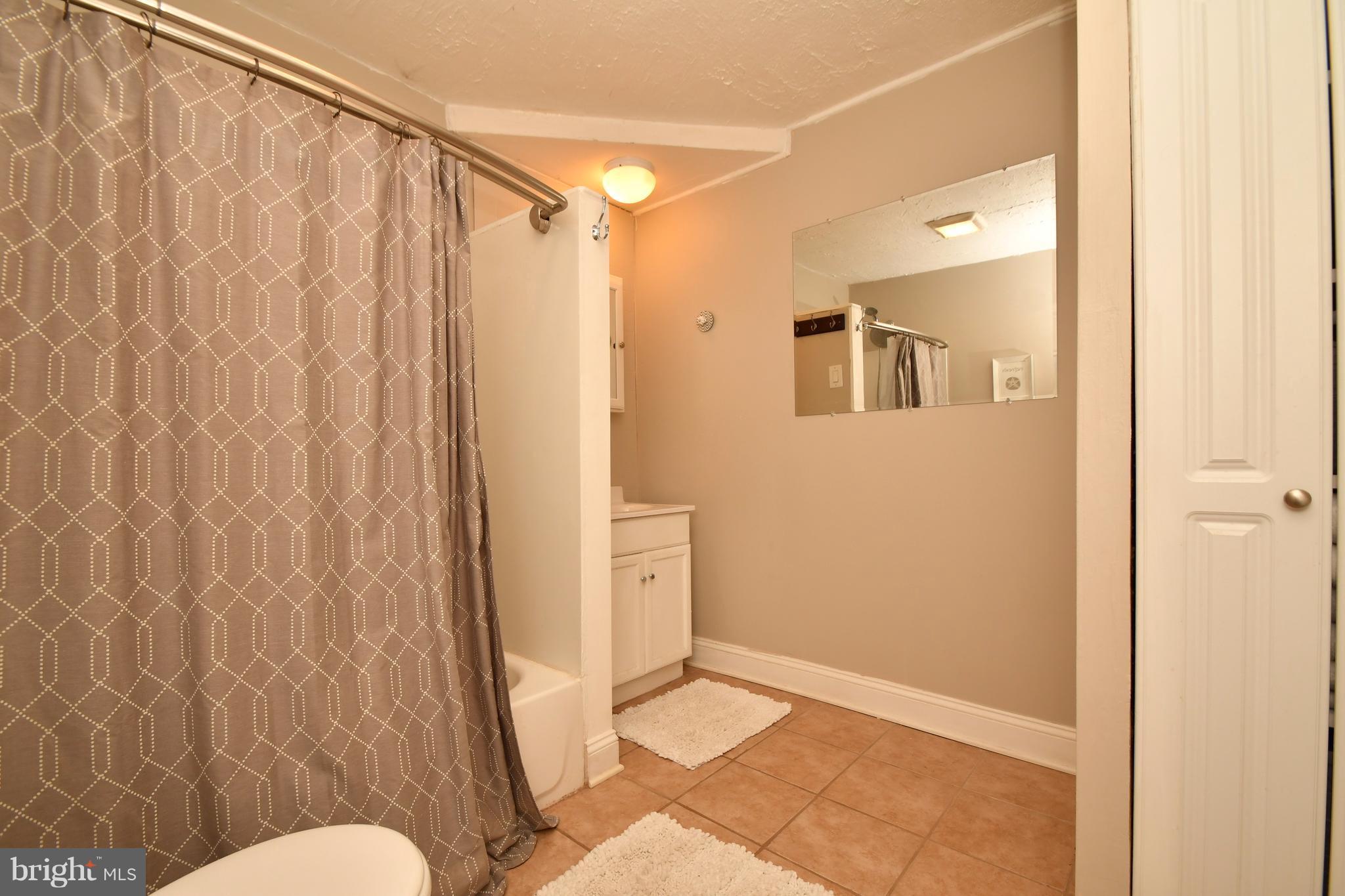 1095 Colora Road Colora, MD 21917 - Photo 19 of 29 a bathroom with a shower curtain and a toilet