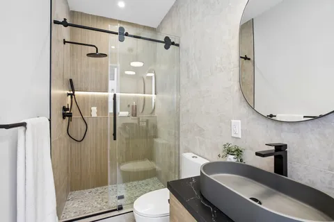a bathroom with a granite countertop sink toilet and shower