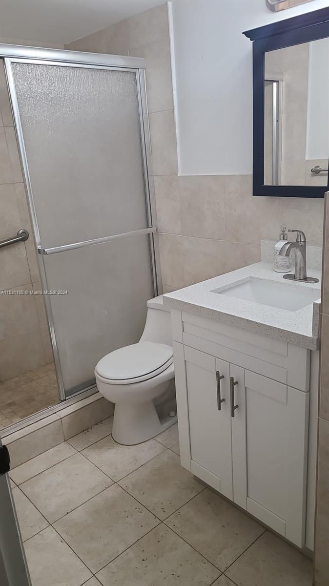 8807 Southwest 130th Place, Unit 102 Miami, FL 33186 - Photo 11 of 18 a bathroom with a sink a toilet and a mirror