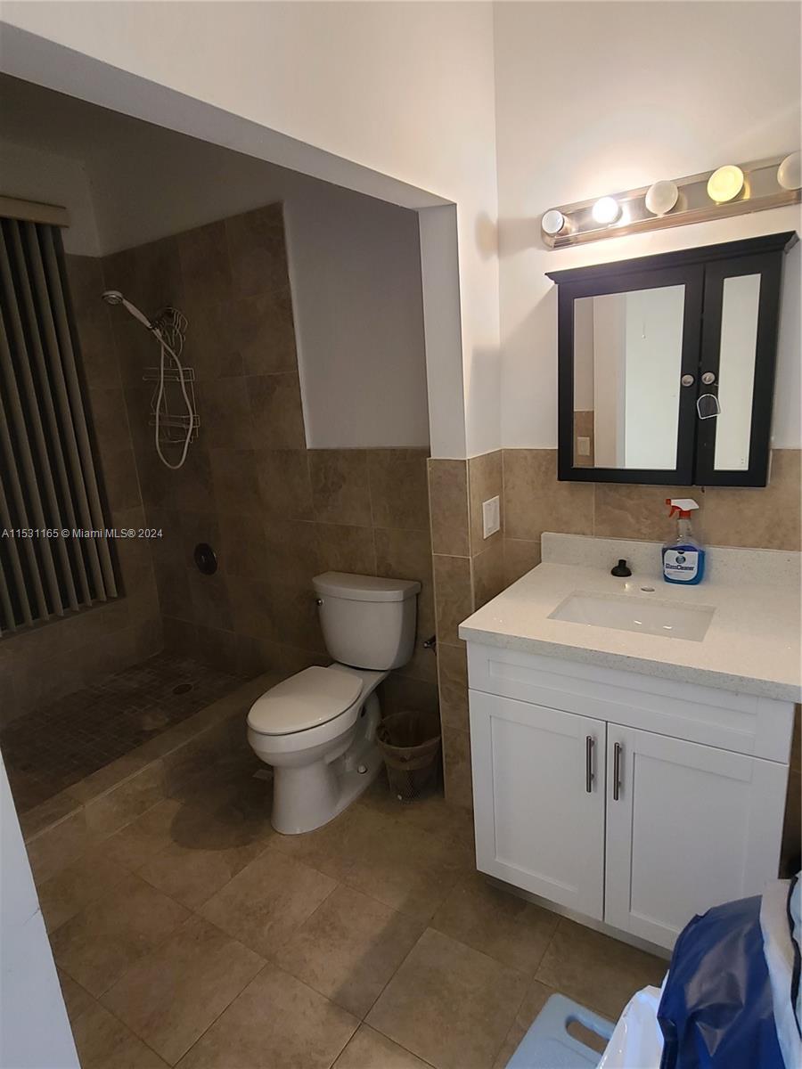 8807 Southwest 130th Place, Unit 102 Miami, FL 33186 - Photo 12 of 18 a bathroom with a toilet sink and mirror