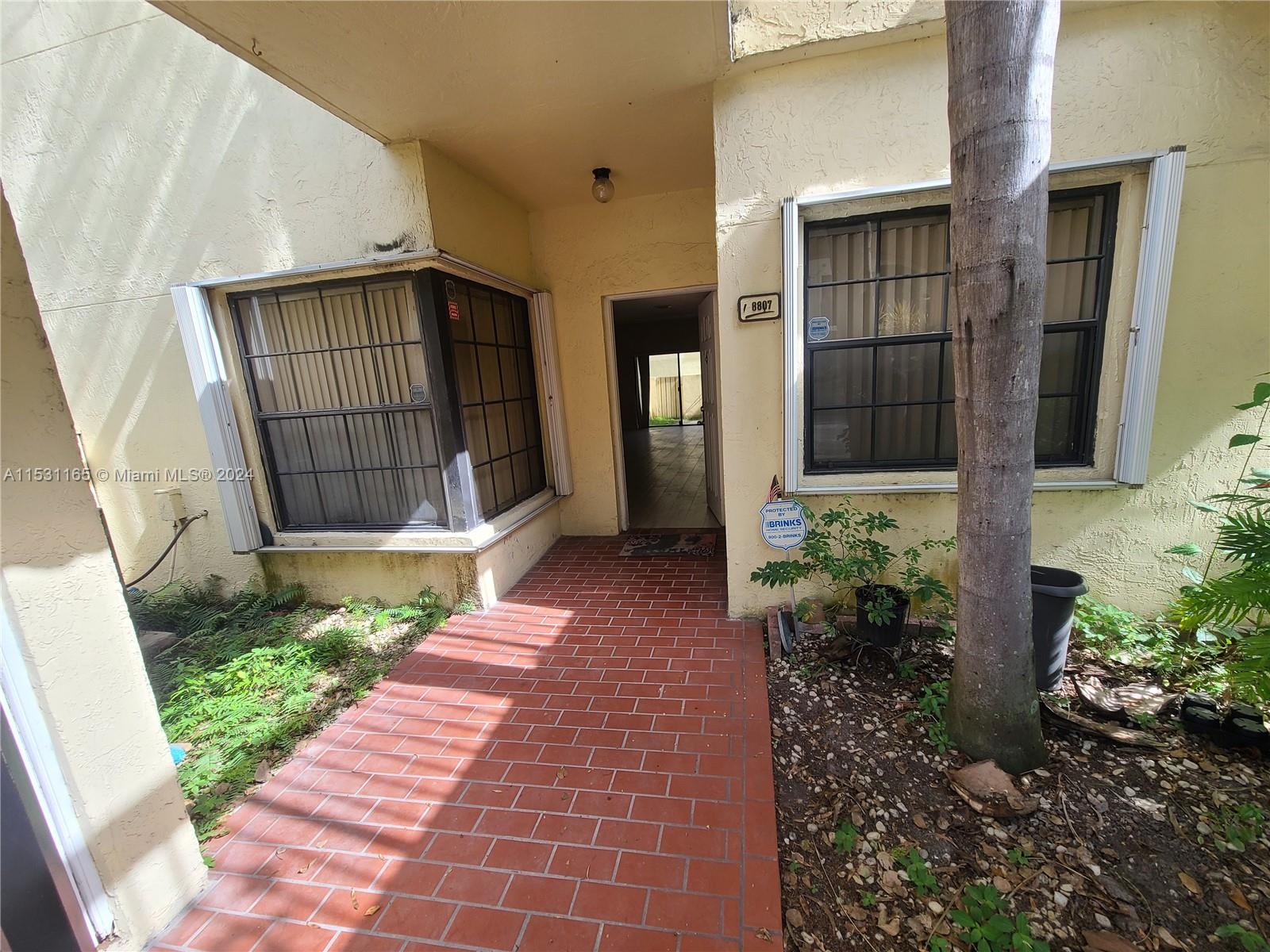 8807 Southwest 130th Place, Unit 102 Miami, FL 33186 - Photo 2 of 18 a view of entrance of house with potted plants
