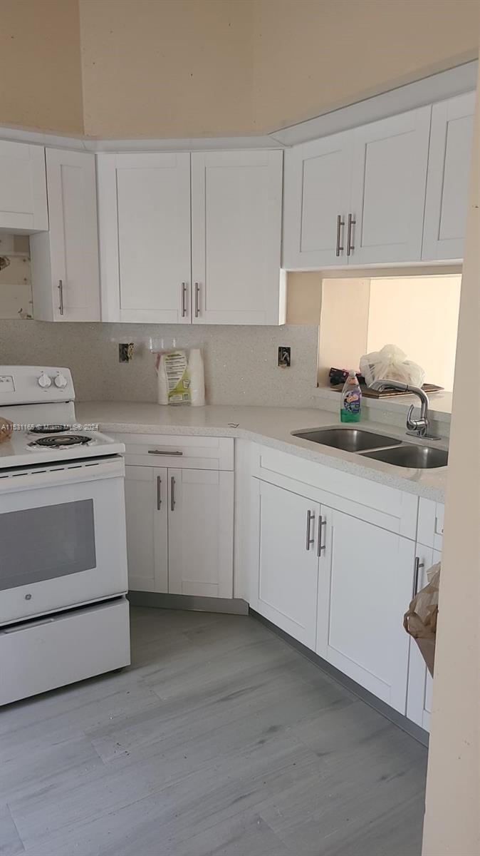 8807 Southwest 130th Place, Unit 102 Miami, FL 33186 - Photo 10 of 18 a kitchen with white cabinets appliances a sink and a window
