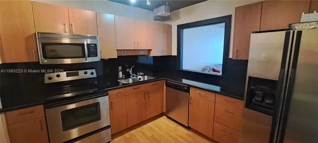 a kitchen with stainless steel appliances granite countertop a refrigerator and a stove top oven