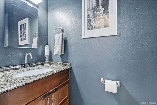 a bathroom with a granite countertop sink and a mirror